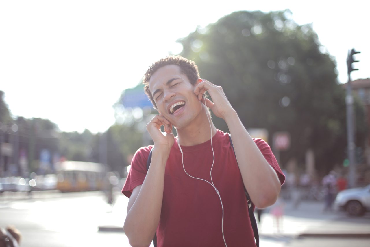 Man listening to headphones and singing along.