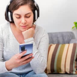 Woman uses phone with headphones