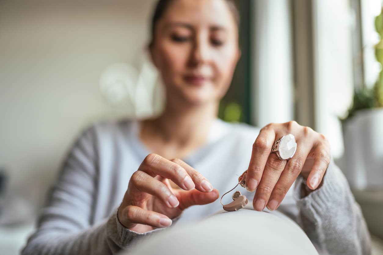 Woman handles her hearing aid