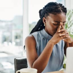 Stressed woman looking at her laptop holding her nasal bridge