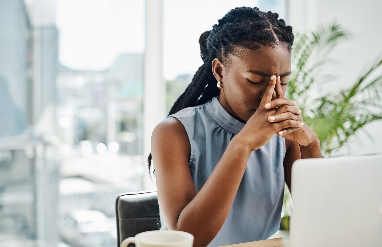 Stressed woman looking at her laptop holding her nasal bridge.