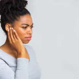 Woman holds hand behind one ear
