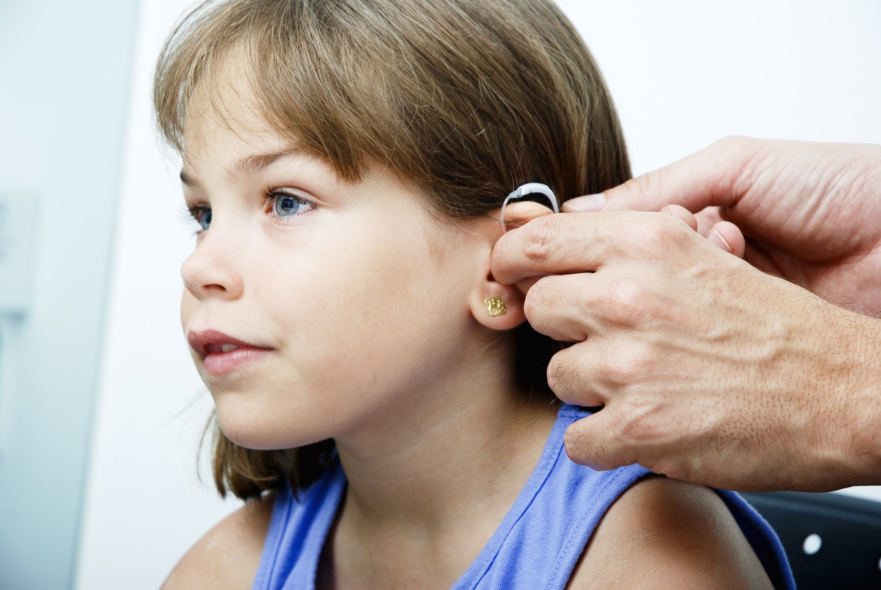 Young girl tries hearing aids