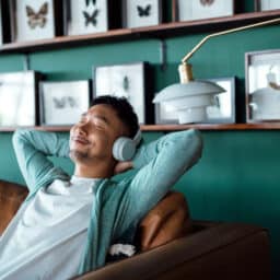 Man wears headphones for sound therapy for tinnitus. He is relaxed, finding relief from tinnitus.