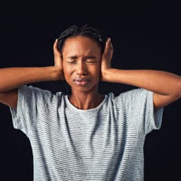 Woman struggling with loud noise, covers her ears.
