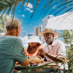 Well-dressed group of friends who love to travel eat lunch on vacation in a tropical location