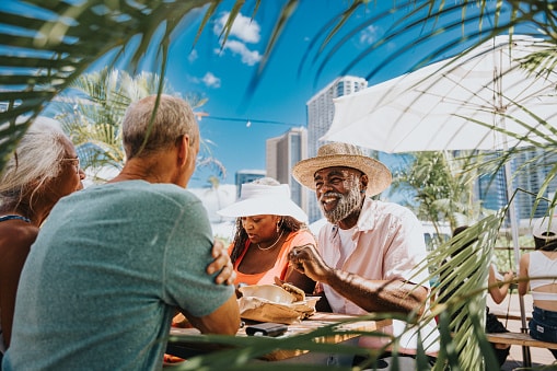 Well-dressed group of friends who love to travel eat lunch on vacation in a tropical location