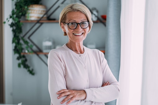 Happy, confident older woman smiles in her home.